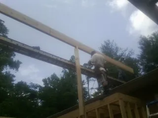 Carpenter setting a ridge beam over a new addition frame — Ice Dam Removal by Roofing Brothers in Scales Mound