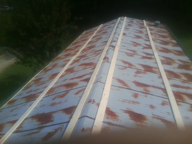 Rusted metal roof panels with new wood purlins before replacement — Storm Damage Roof Repair in Scales Mound by Roofing Brothers