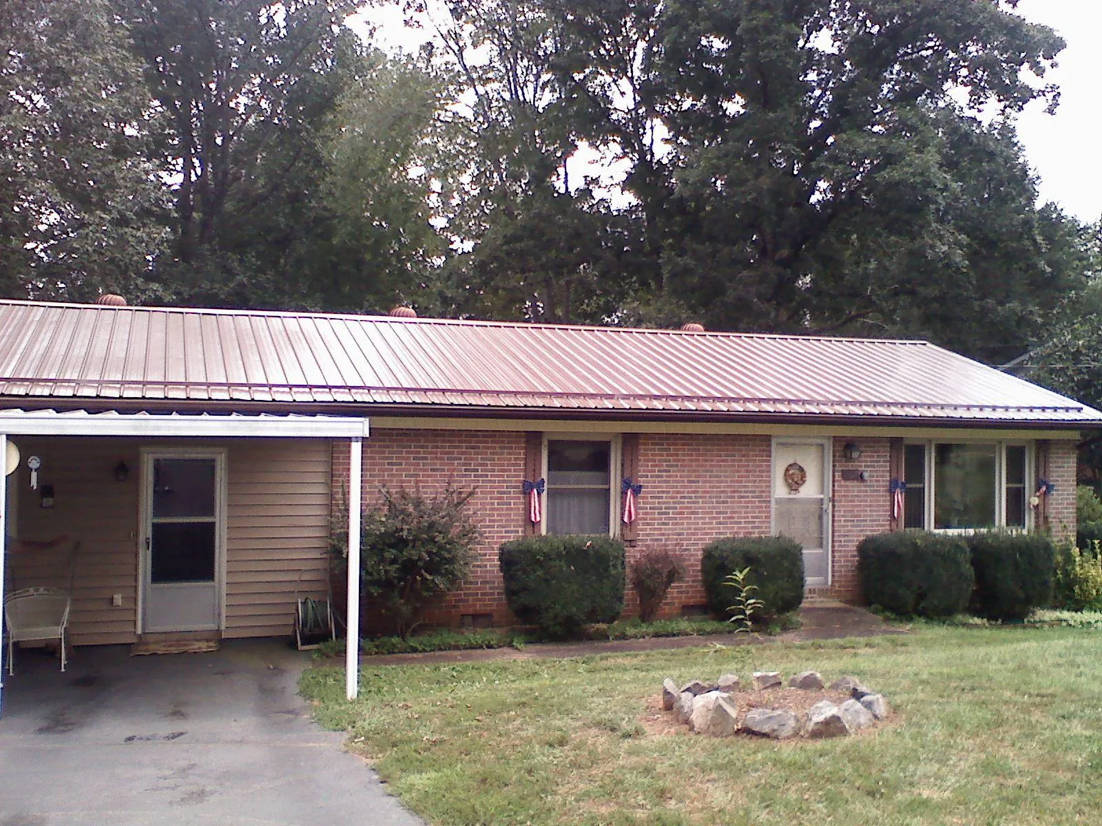 Bronze metal roof and carport on a brick ranch home — Roof Repair work by our crew in Scales Mound